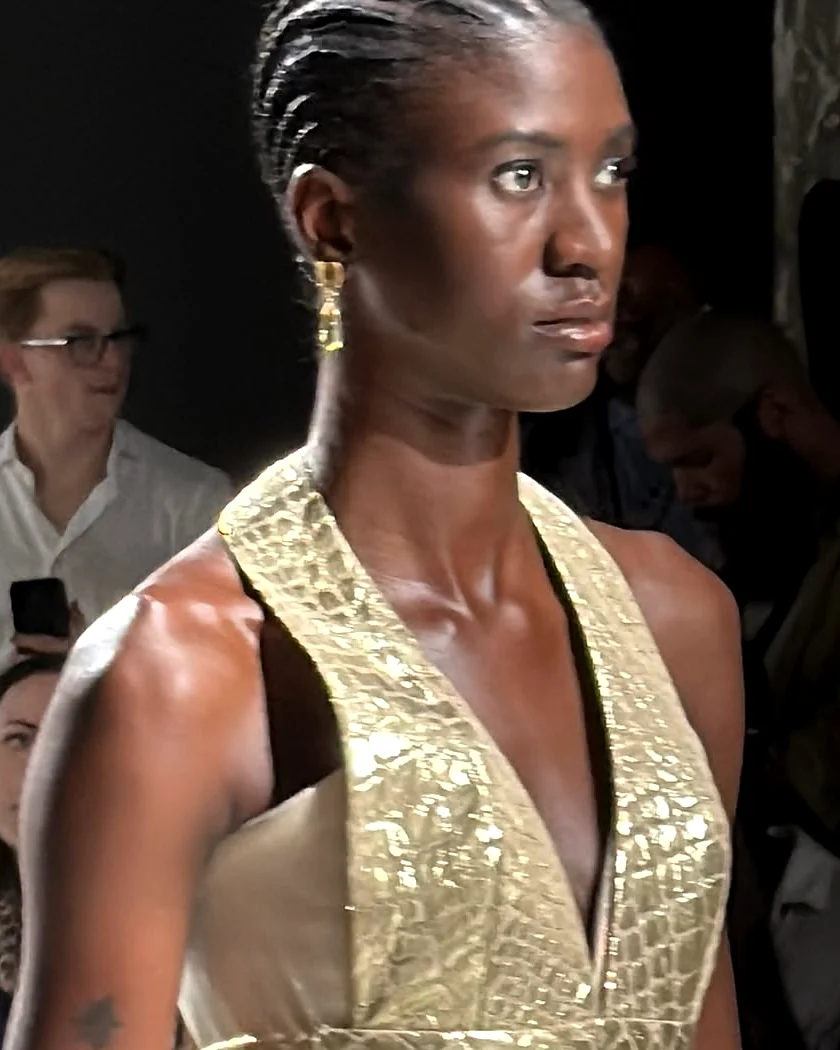 Крупний план макіяжу моделі з косами та золотими сережками на Paris Fashion Week – образ для подіуму, не наречена